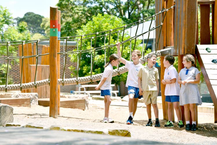 Students at the wooden play equipment
