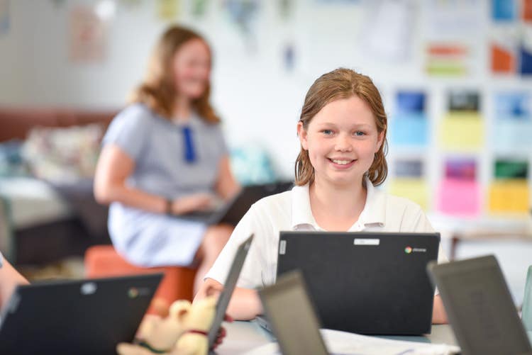 Student working on a lap top in a classroom