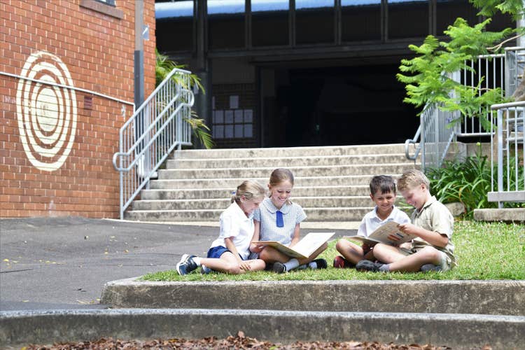 Senior and junior students reading together outside the SPS Hall