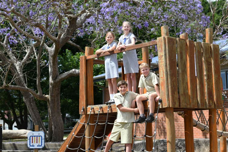 Four students on the wooden play equipment